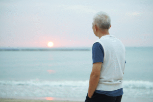 Older man looking at the horizon on the beach